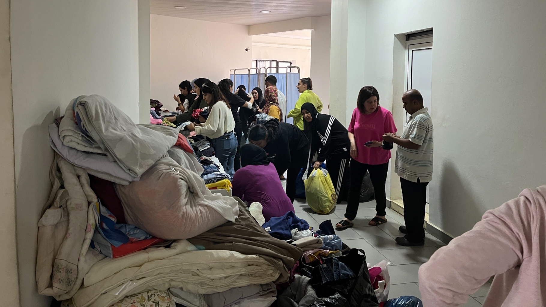 Displaced Lebanese people receive aid in Dhour el-Choueir's municipality building on 26 September 2024 (Nader Durgham/MEE)