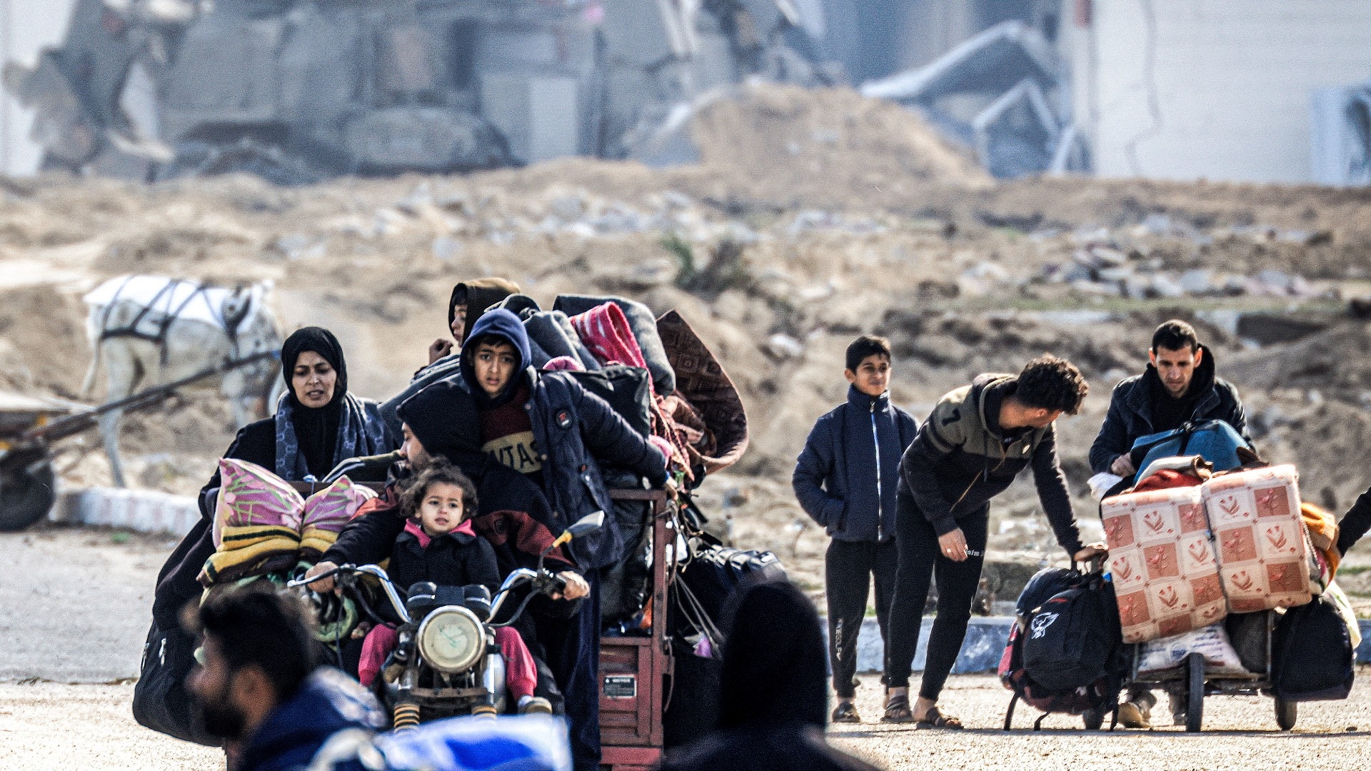 Displaced Palestinians flee from Khan Younis in the southern Gaza Strip on 30 January 2024 (Mahmud Hams/AFP)