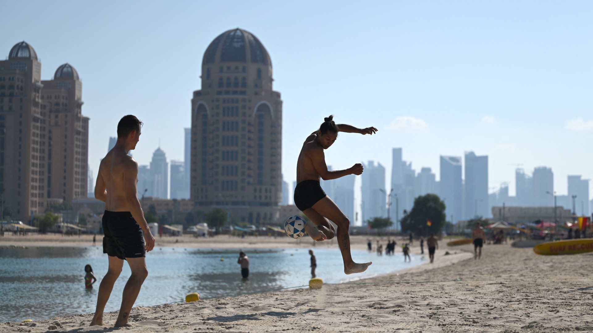 Men play football at Katara beach in Doha in December 2022 (AFP/Gabriel Bouys)