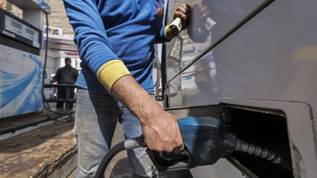 A worker fills the tank of a vehicle at a petrol station in Cairo on 2 March 2023 as Egypt’s government announced a new increase in fuel prices (AFP)
