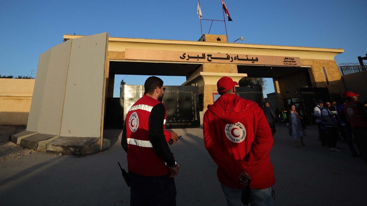 A Red Crescent humanitarian society representative walks by Egypt's eastern border with the Gaza Strip in Rafah on 11 December 2023.