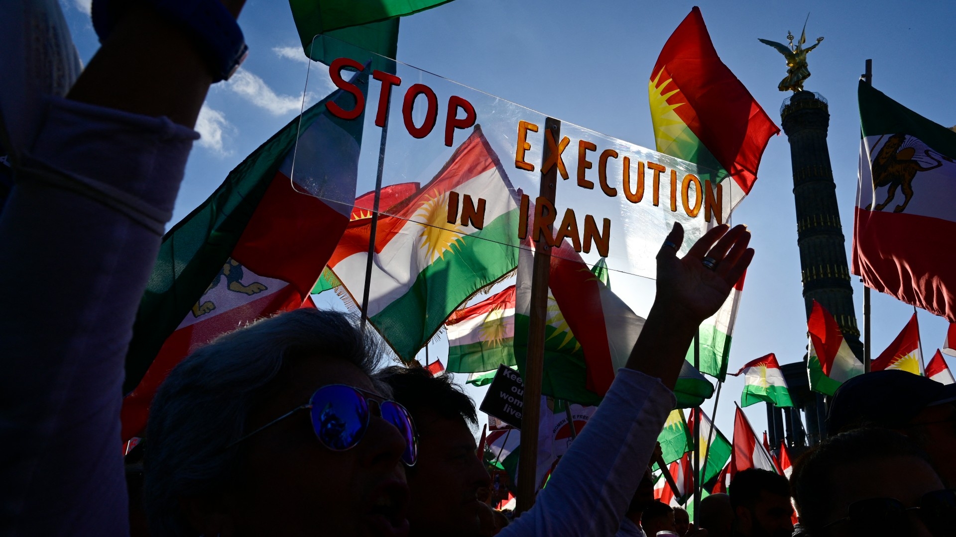 Protesters take part in a rally in support of the demonstrations in Iran in front of the Victory Column (Siegessaeule) in Berlin on 22 October 2022 (AFP)