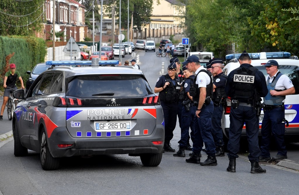 Des policiers se tiennent dans une rue où se trouve une maison appartenant à la famille de l’imam Hassan Iquioussen, à Lourches, dans le nord de la France, le 30 août 2022 (AFP/François Lo Presti)