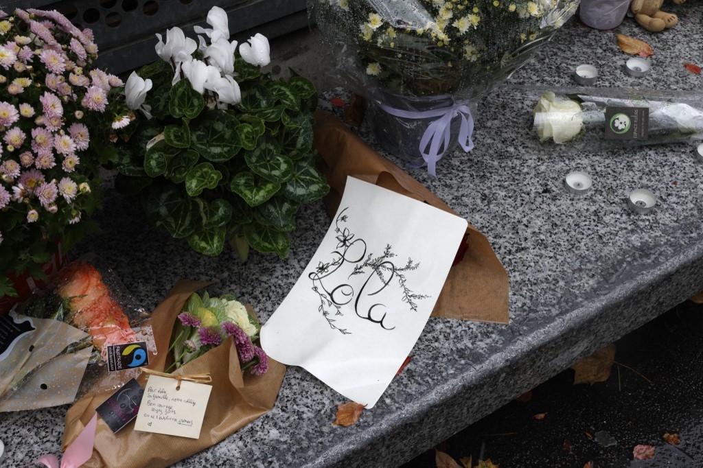Des fleurs exposées devant le collège Georges Brassens à Paris le 17 octobre 2022, où étudiait Lola, 12 ans, trois jours après la découverte de son corps dans une malle (AFP/Geoffroy Van der Hasselt)