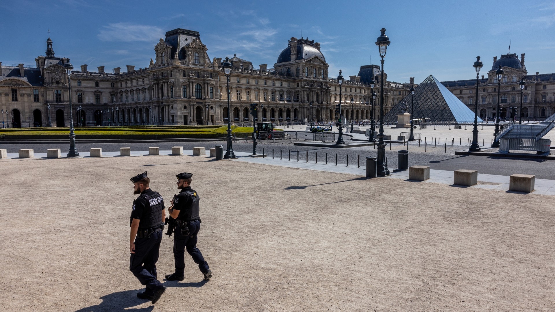 French Gendarmes carry out security checks next to the Louvre Museum, closed to traffic for pedestrians, cyclists and vehicles as a security measure in Paris on 18 July 2024 (AFP/Joel Saget)