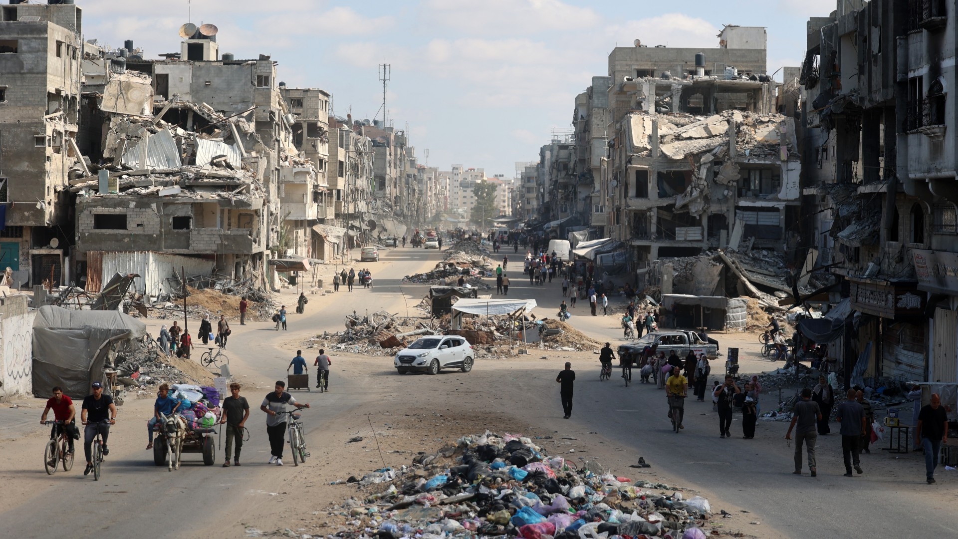 Palestinians carry their belongings as they are forced flee areas north of Gaza City in the northern Gaza Strip on 12 October 2024 (AFP/Omar al-Qattaa)