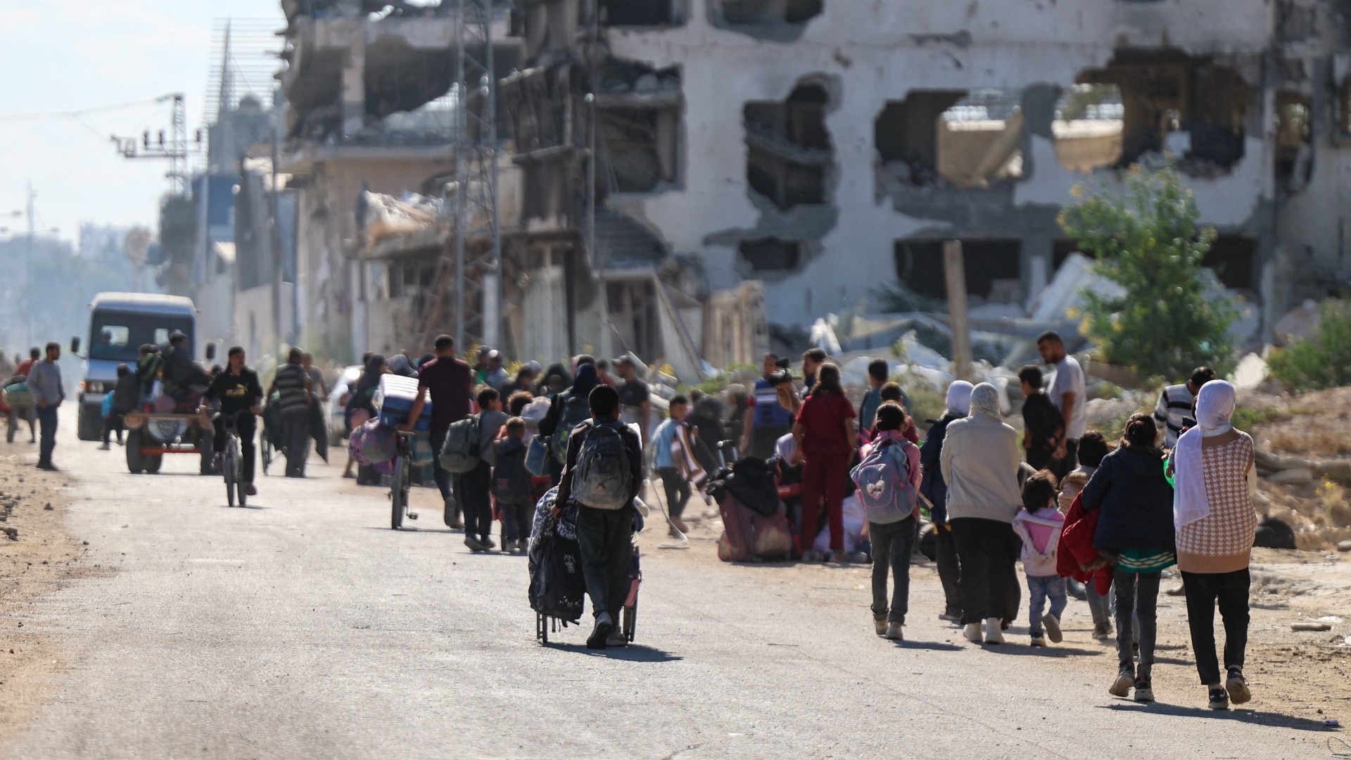 Displaced Palestinians fleeing Israeli military operations in Beit Lahia in the northern Gaza strip walk along the Salah al-Din main road in eastern Gaza City making their way to the city centre, on 22 October 2024 (AFP/Omar al-Qattaa)