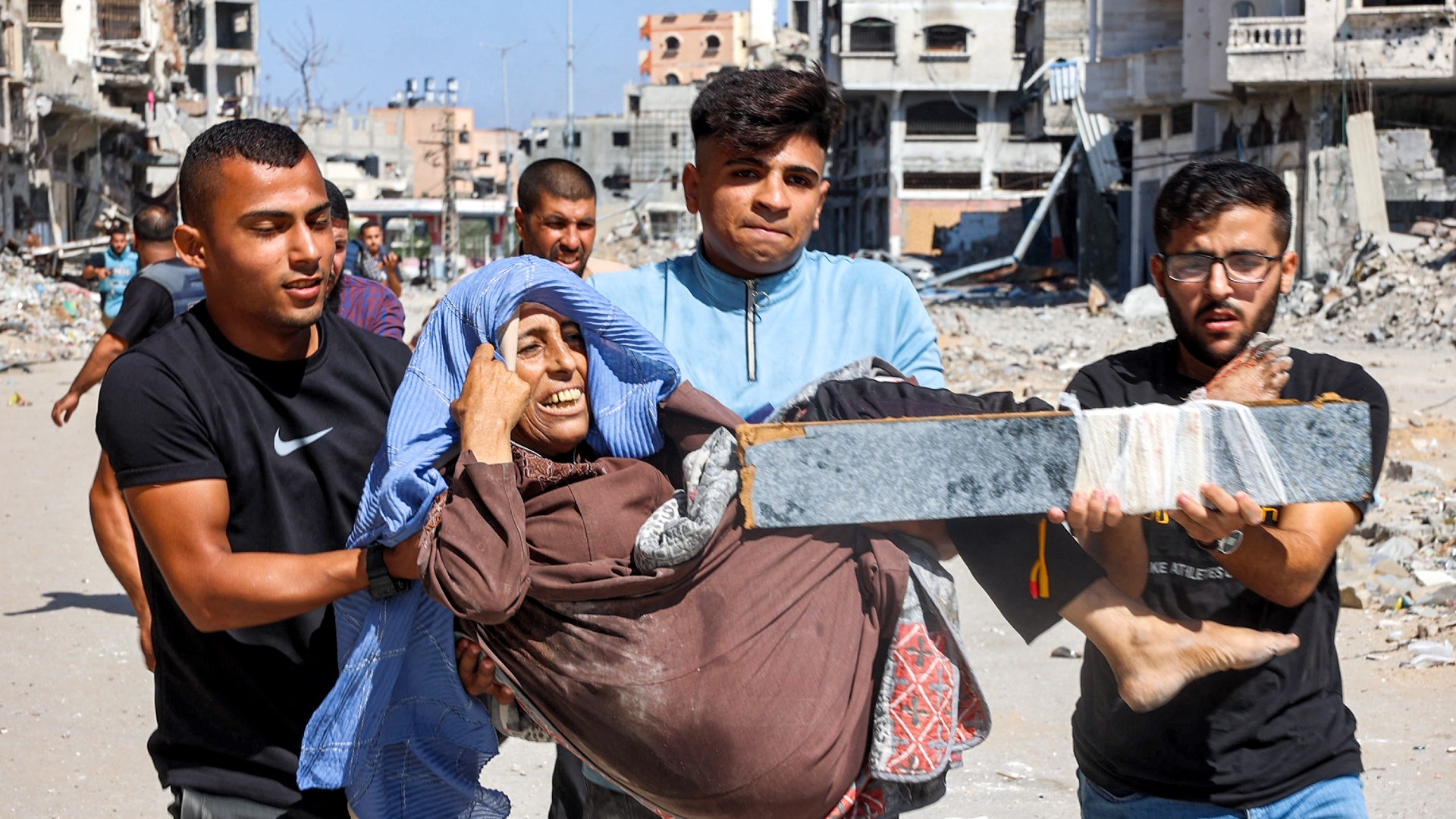 Men carry injured woman to be evacuated in the Jabalia camp for Palestinian refugees in the northern Gaza Strip on 9 October 2024 (Omar AL-QATTAA/AFP)