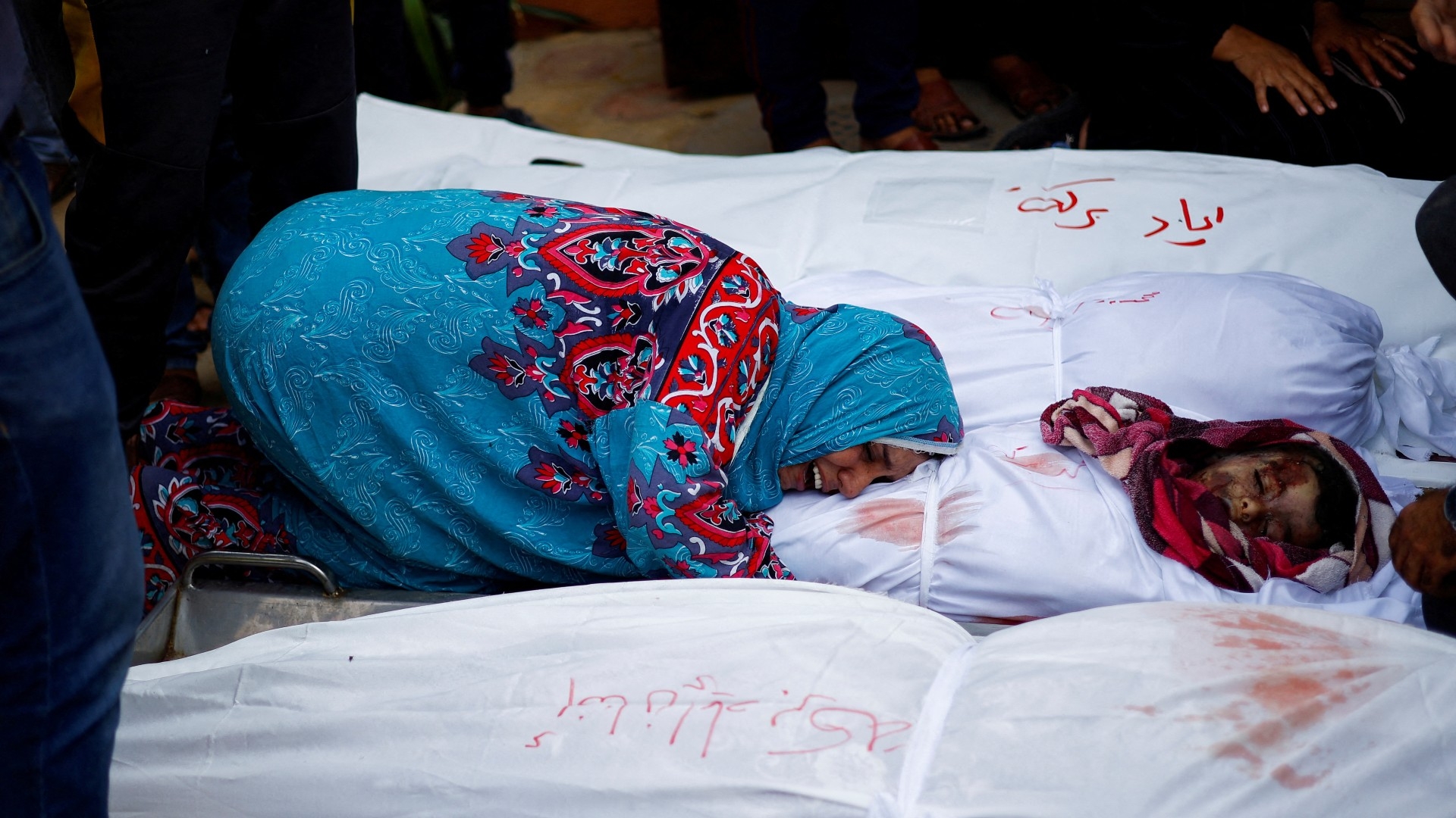 A relative of Baraka and Abu Reda mourns near their bodies at a hospital, following Israeli strikes, in Khan Younis in the southern Gaza Strip 13 November 2023 (Reuters)