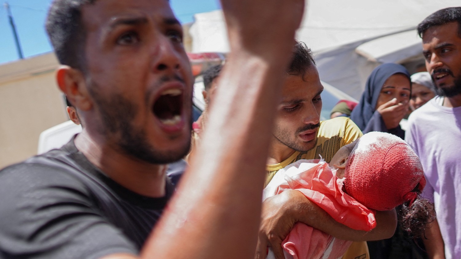 Sami, the father of Palestinian girl Hour Sami Dawood Abu al-Rous, 4, reacts as a relative carries her body after she was killed in an Israeli strike on a house in Nuseirat, at the Al-Aqsa Martyrs Hospital in Deir al-Balah in the central Gaza Strip on 3 July 2024.