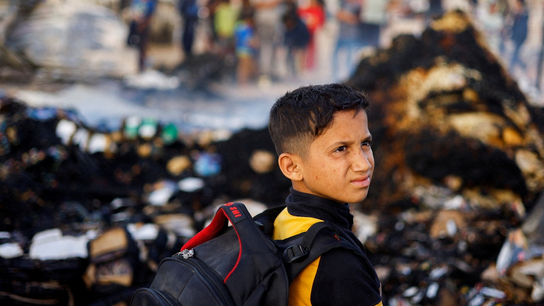 A Palestinian boy looks on at the site of an Israeli strike on an area designated for displaced people, in Rafah in the southern Gaza Strip, 27 May 2024 (Reuters/Mohammed Salem)