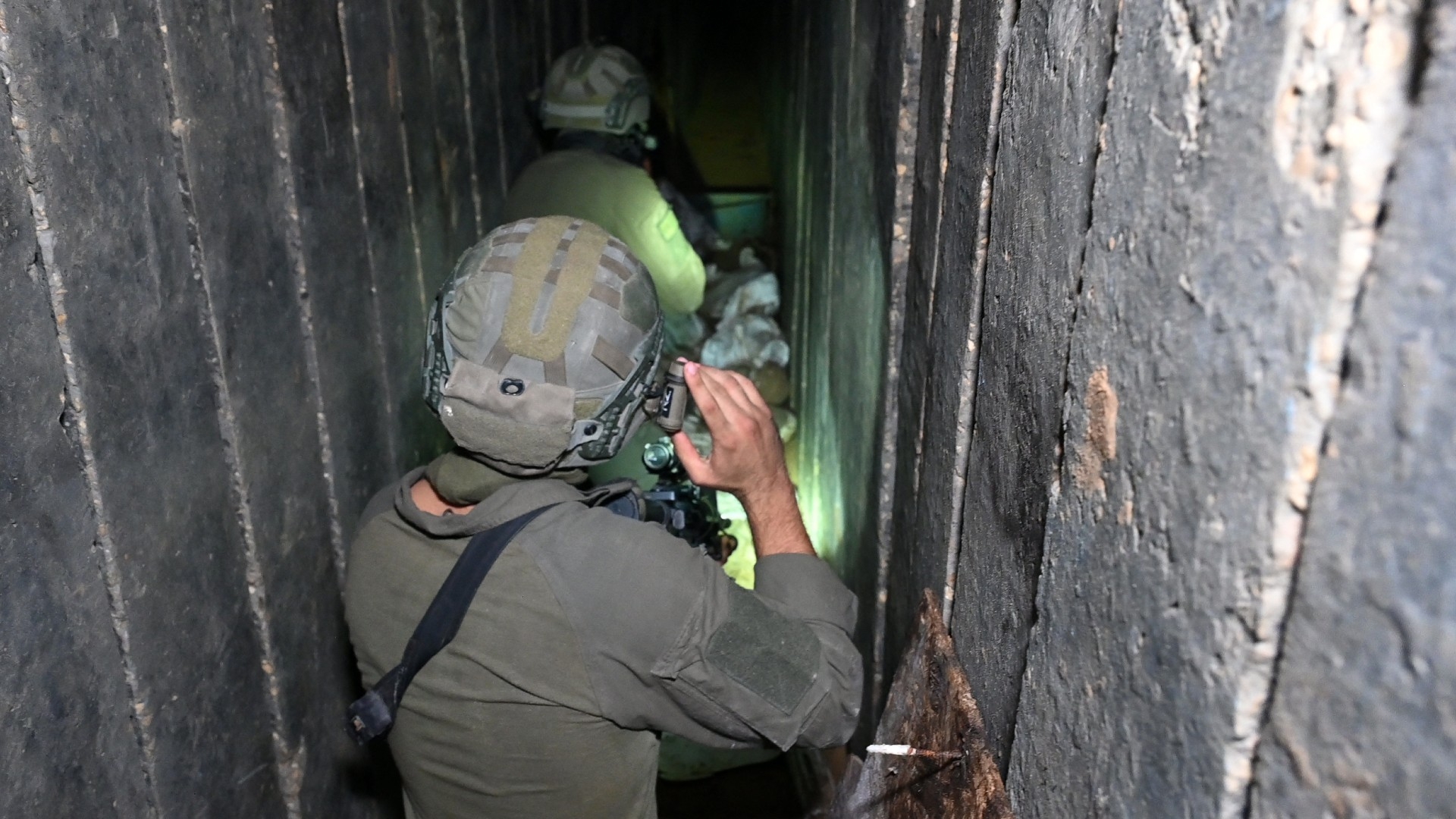 Israeli soldiers walk through what they described as a tunnel in the northern Gaza Strip on 22 November 2023 (AFP)