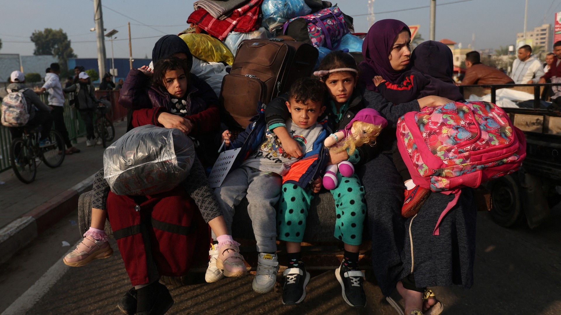 Women with children sit in a trailer, as Palestinians flee their houses due to Israeli strikes, after a temporary truce between Hamas and Israel expired, in the eastern part of Khan Younis in the southern Gaza Strip, December 1, 2023 (Reuters)