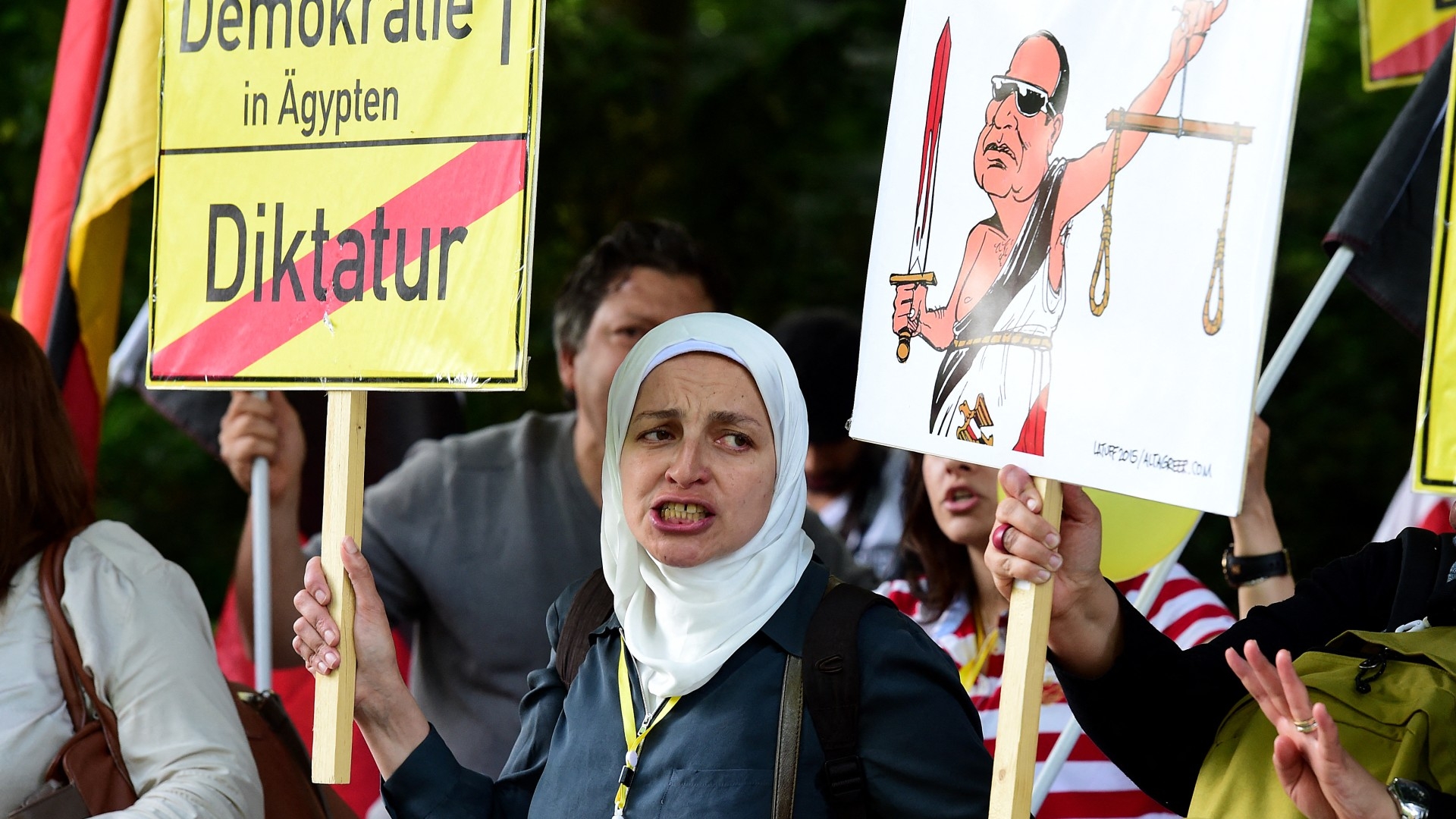 In this file photo, a protester holds a banner prior to the arrival of Egyptian President Abdel Fattah al-Sisi in Berlin on 3 June 2015 (AFP)