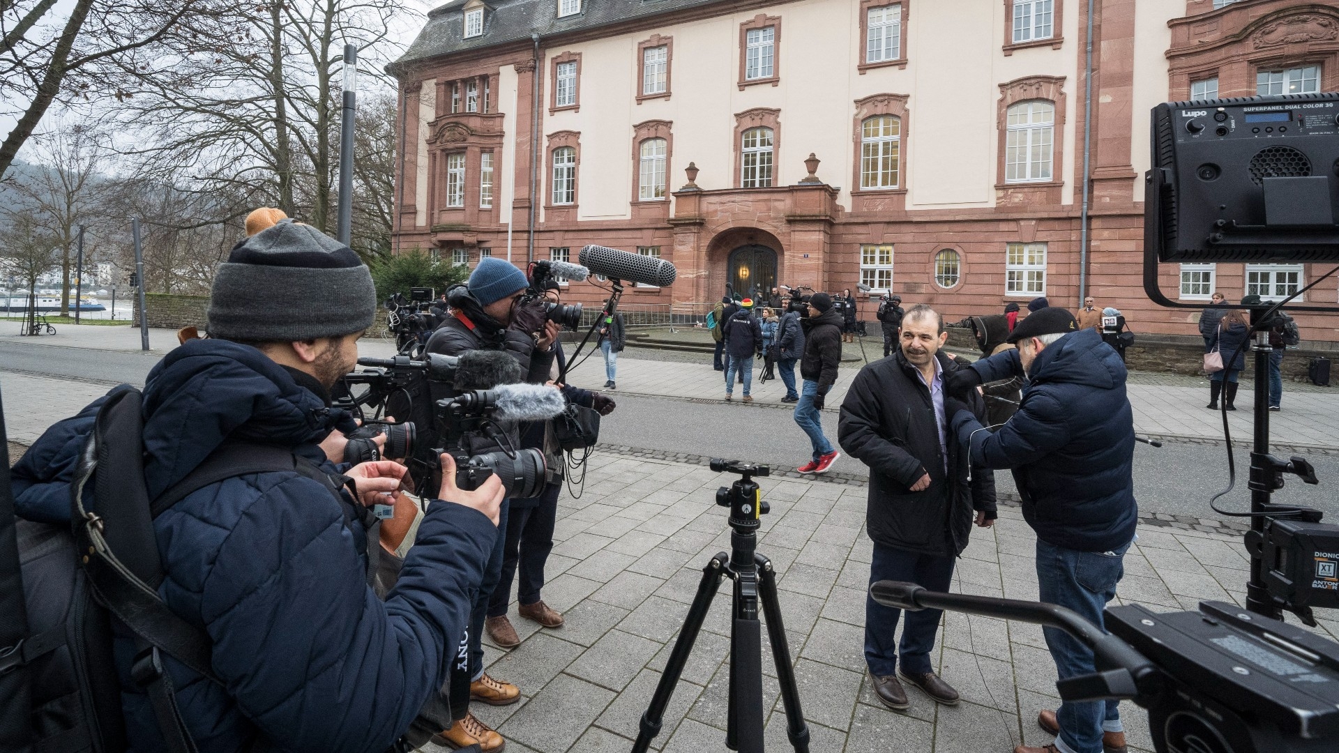 Journalists stand outside the courthouse in Koblenz, western Germany, on 13 January 2022, during the trial of former Syrian intelligence officer Anwar Raslan (AFP/File photo)