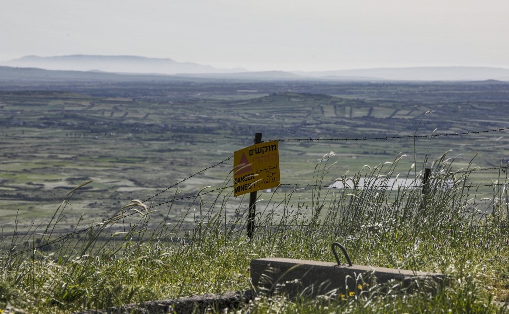 A sign warning against landmines is seen by a barbed-wire fence near the border fence separating the occupied Golan Heights from the rest of Syria.