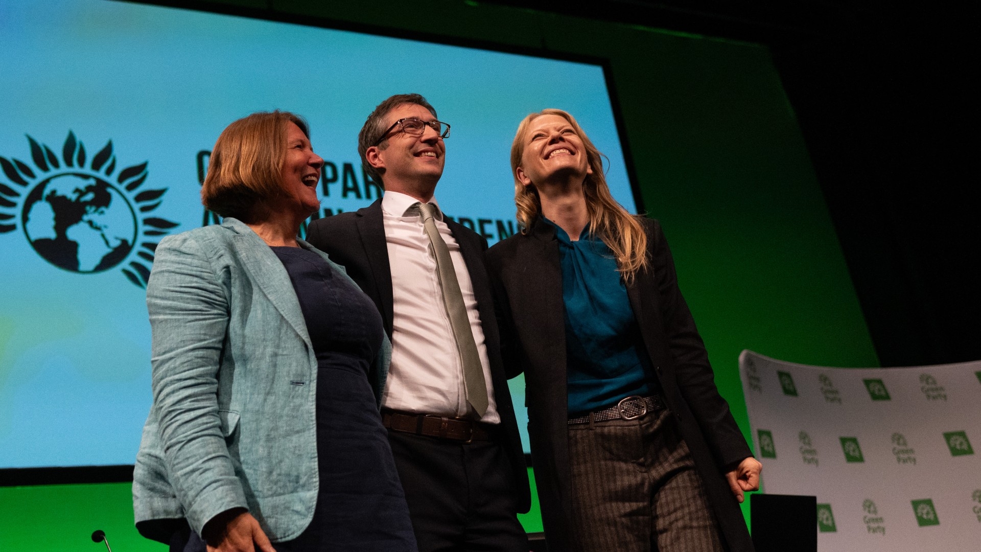 Green Party co-leader Adrian Ramsay is joined on stage by MPs Sian Berry and Ellie Chowns during the annual party conference in Manchester on 6 September (Reuters)