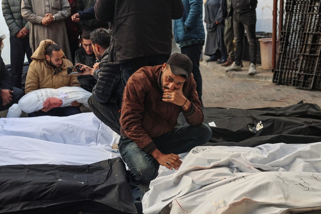 Les Palestiniens pleurent près des corps de leurs proches à l’hôpital de Rafah, le 21 février 2024, à la suite des frappes aériennes israéliennes nocturnes sur le sud de la bande de Gaza (AFP/Said Khatib)
