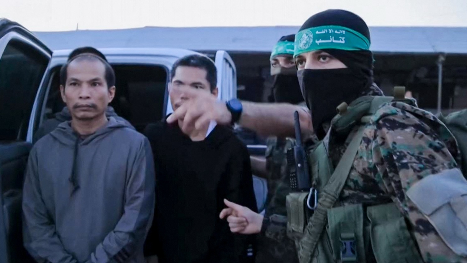 A video released by the Hamas media office shows members of the Qassam Brigades handing over hostages to officials from the International Committee of the Red Cross in Gaza on 24 November 2023 (Hamas Media Office/AFP)