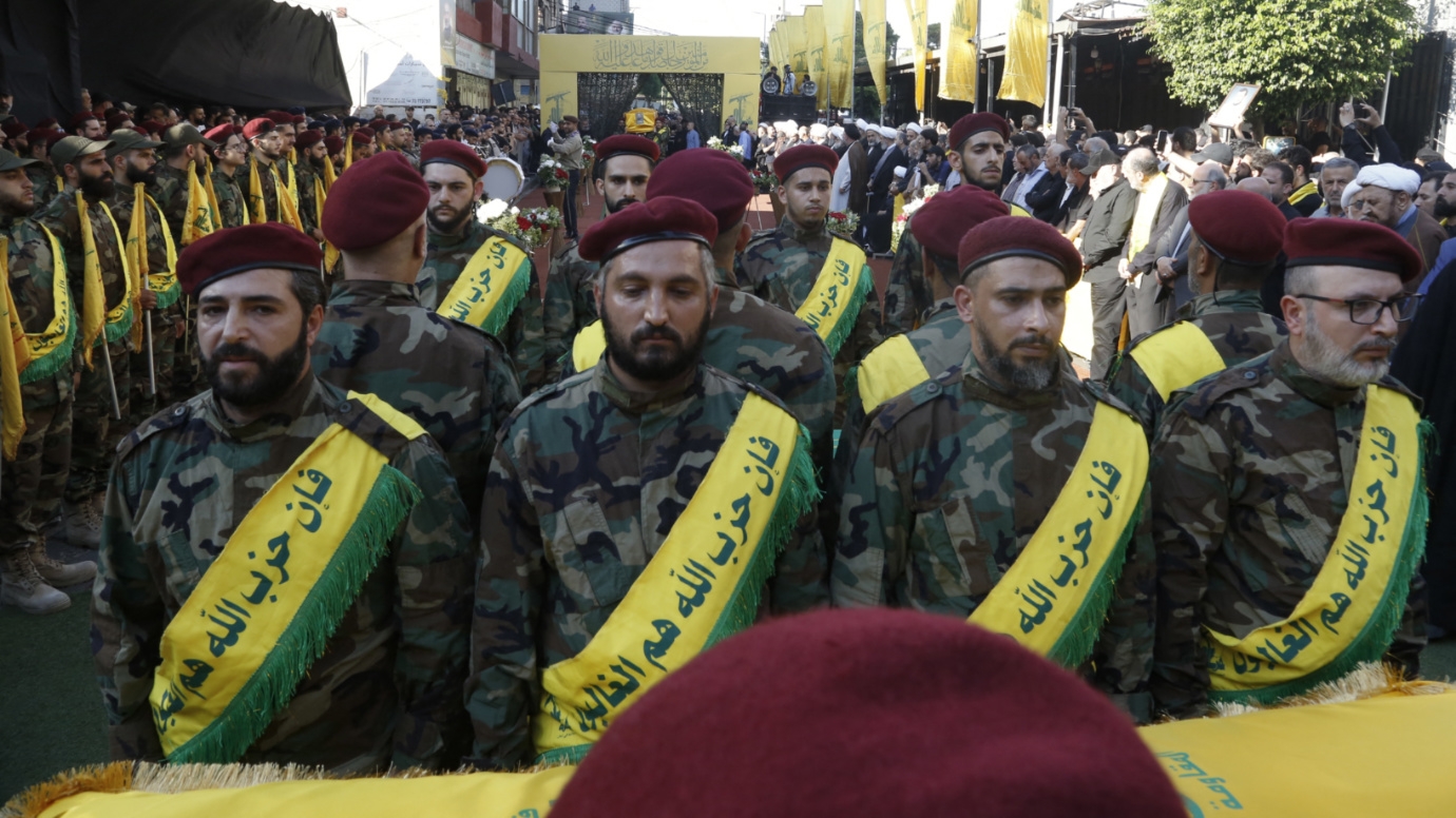 Hezbollah fighters stand in front of the flag-draped coffin of killed commander Mohammed Srur on 27 September 2024 in Beirut (AFP)