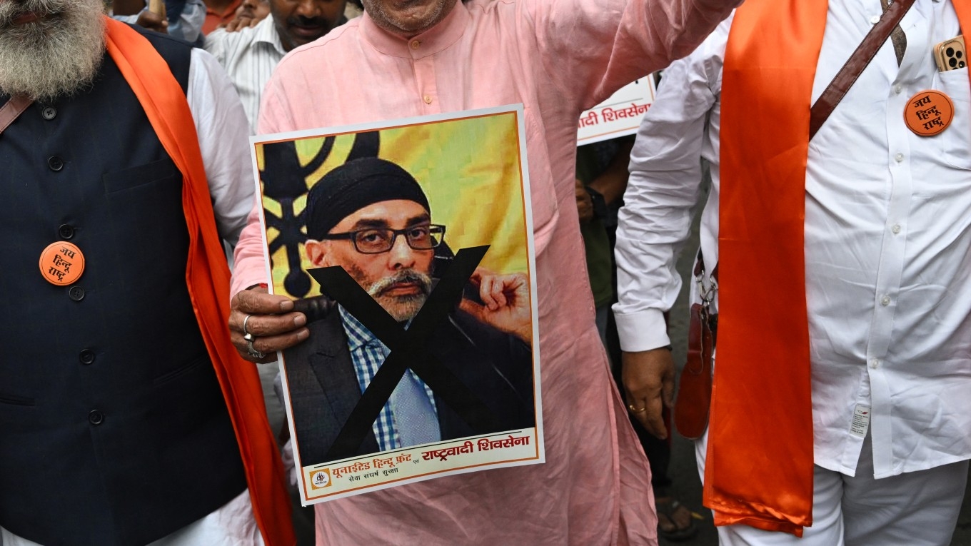 Hindu nationalists shout slogans while holding a banner depicting Gurpatwant Singh Pannun during a rally along a street in New Delhi on 24 September 2023.