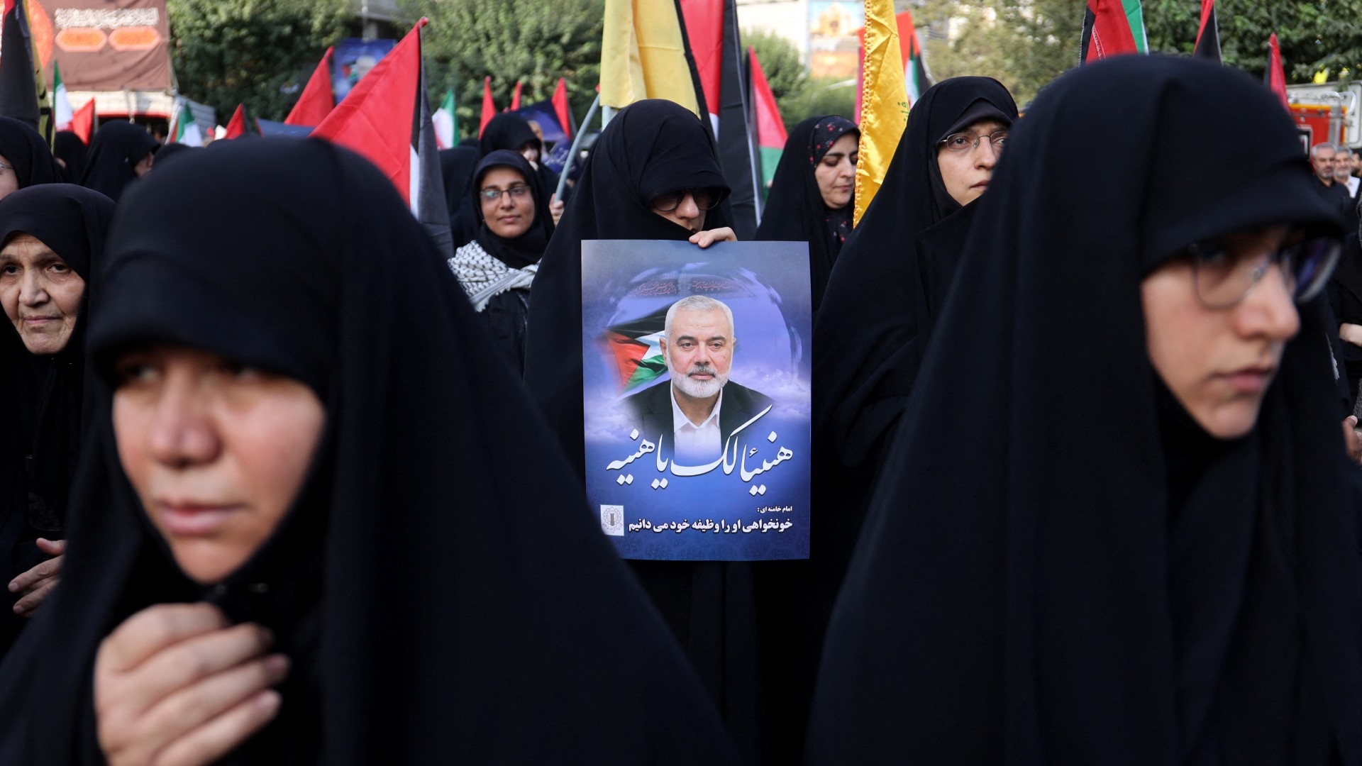 A person holds a poster of Ismail Haniyeh during an anti-Israel gathering following the killing of him, in Tehran 31 July (Reuters/Majid Asgaripour/WANA)