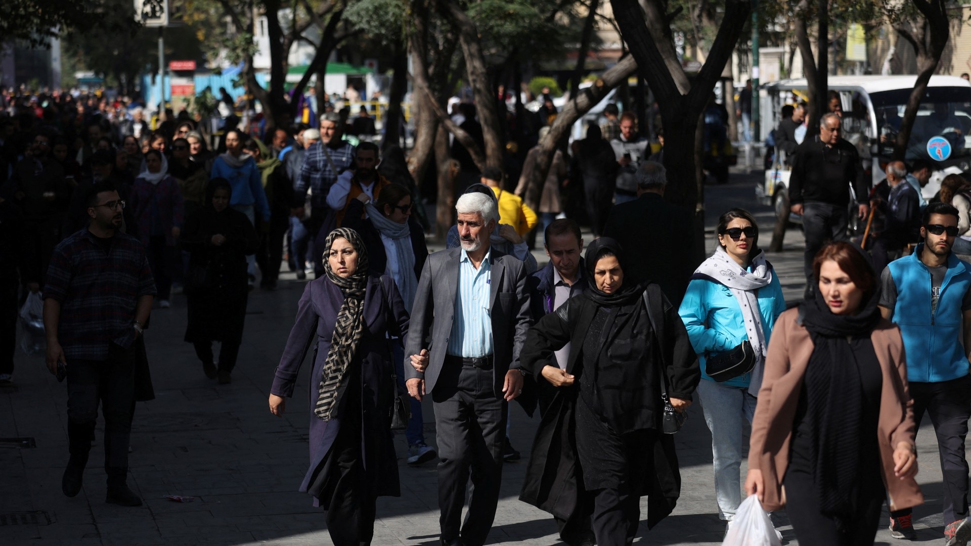 Iranians walk along a street following Israel’s overnight attacks on military targets in Tehran on 26 October 2024 (Majid Asgaripour/WANA via Reuters)