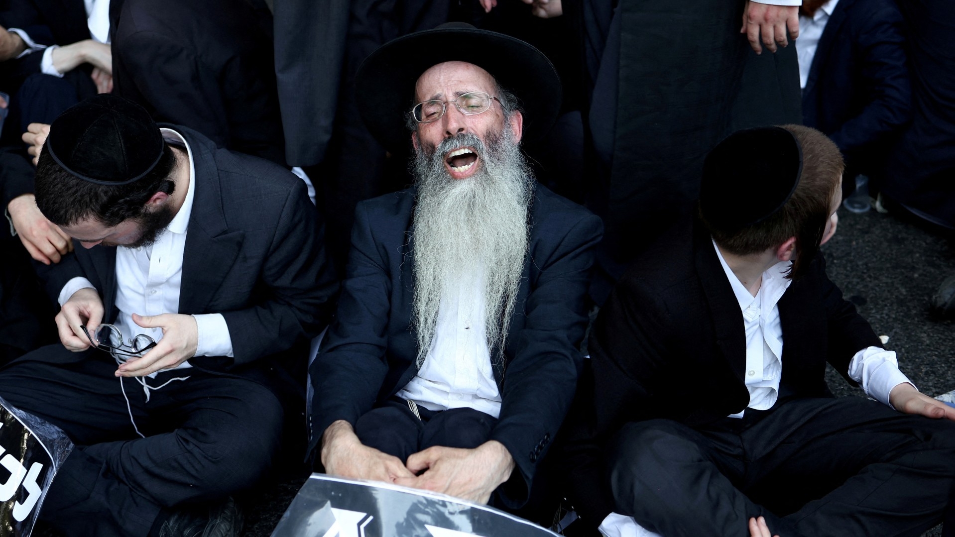Ultra-Orthodox men protest in Bnei Brak, Israel, on 27 June following a ruling requiring the state to begin drafting seminary students into the military (Reuters/Eloisa Lopez)