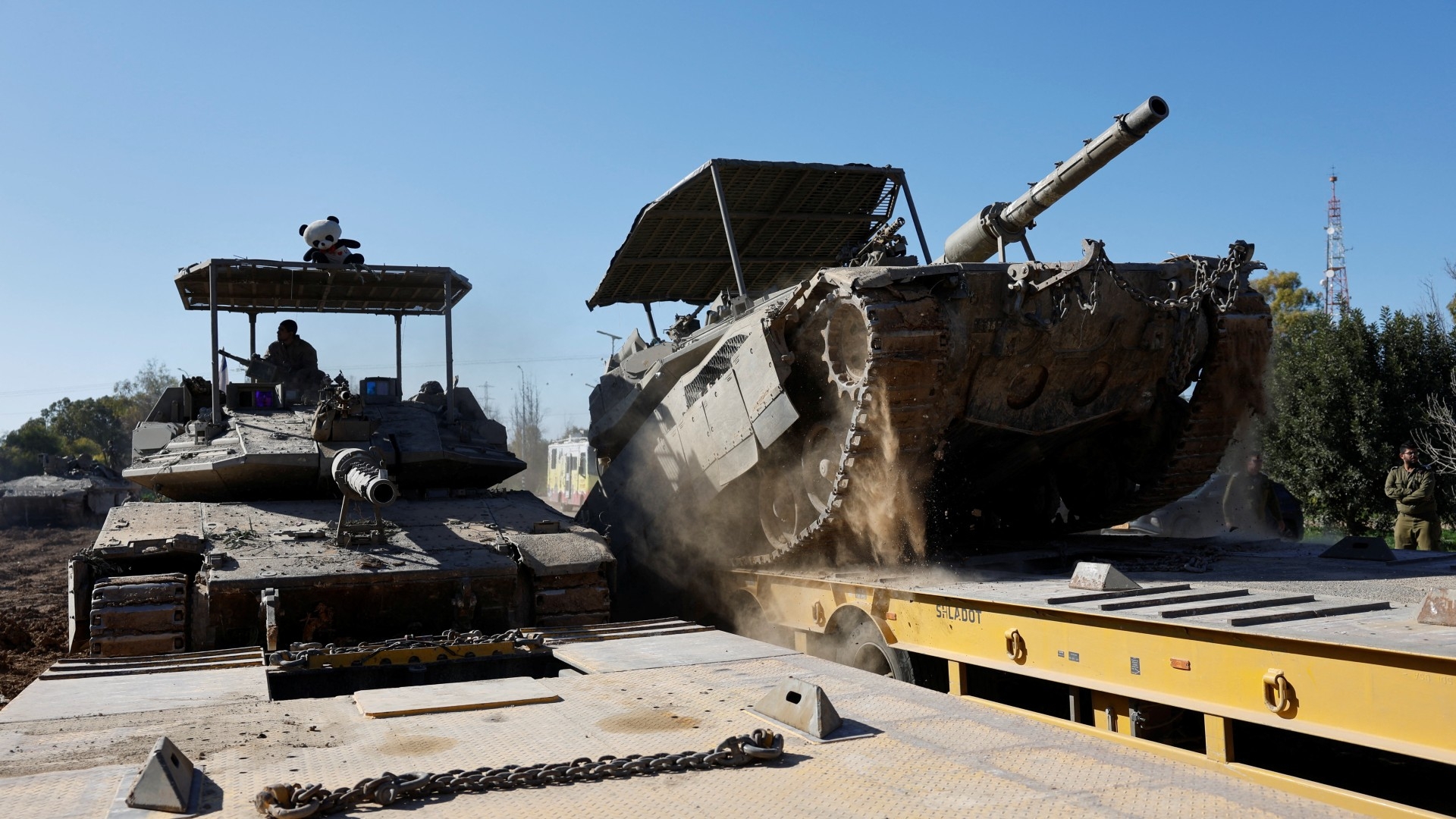 Israeli military tanks are loaded onto a carrier truck after returning from the Gaza Strip (Reuters/Amir Cohen)