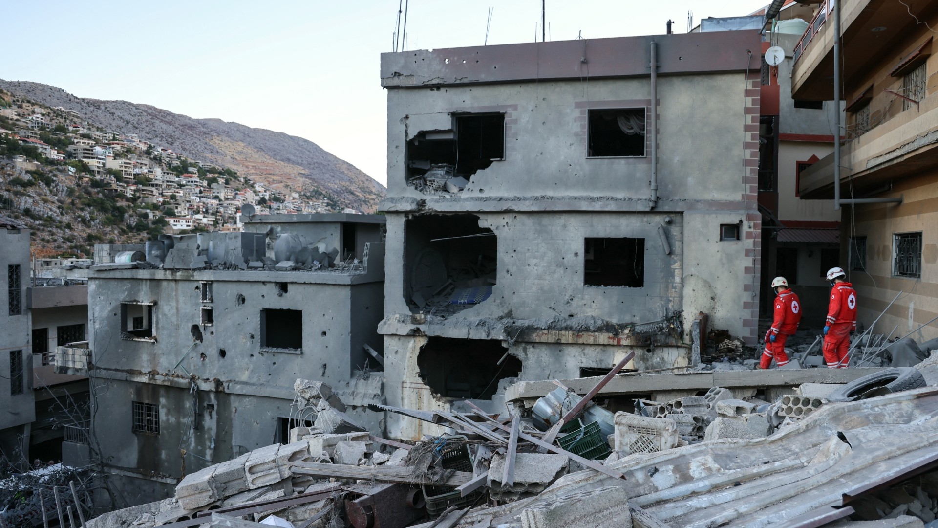 Rescuers check the destruction following an overnight Israeli air strike in the southern Lebanese village of Shebaa near along the border between the two countries, on 27 September 2024 (AFP/Rabih Daher)