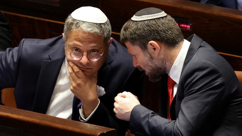 Far-right Israeli ministers Itamar Ben Gvir and Bezalel Smotrich chat at the Knesset in Jerusalem on 15 November 2022 (Abir Sultan/AFP)