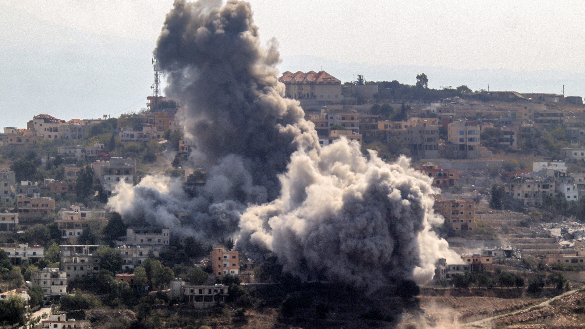 A cloud of smoke erupts following an Israeli air strike on the village of Khiam in southern Lebanon near the border with Israel on 7 October 2024 (AFP)