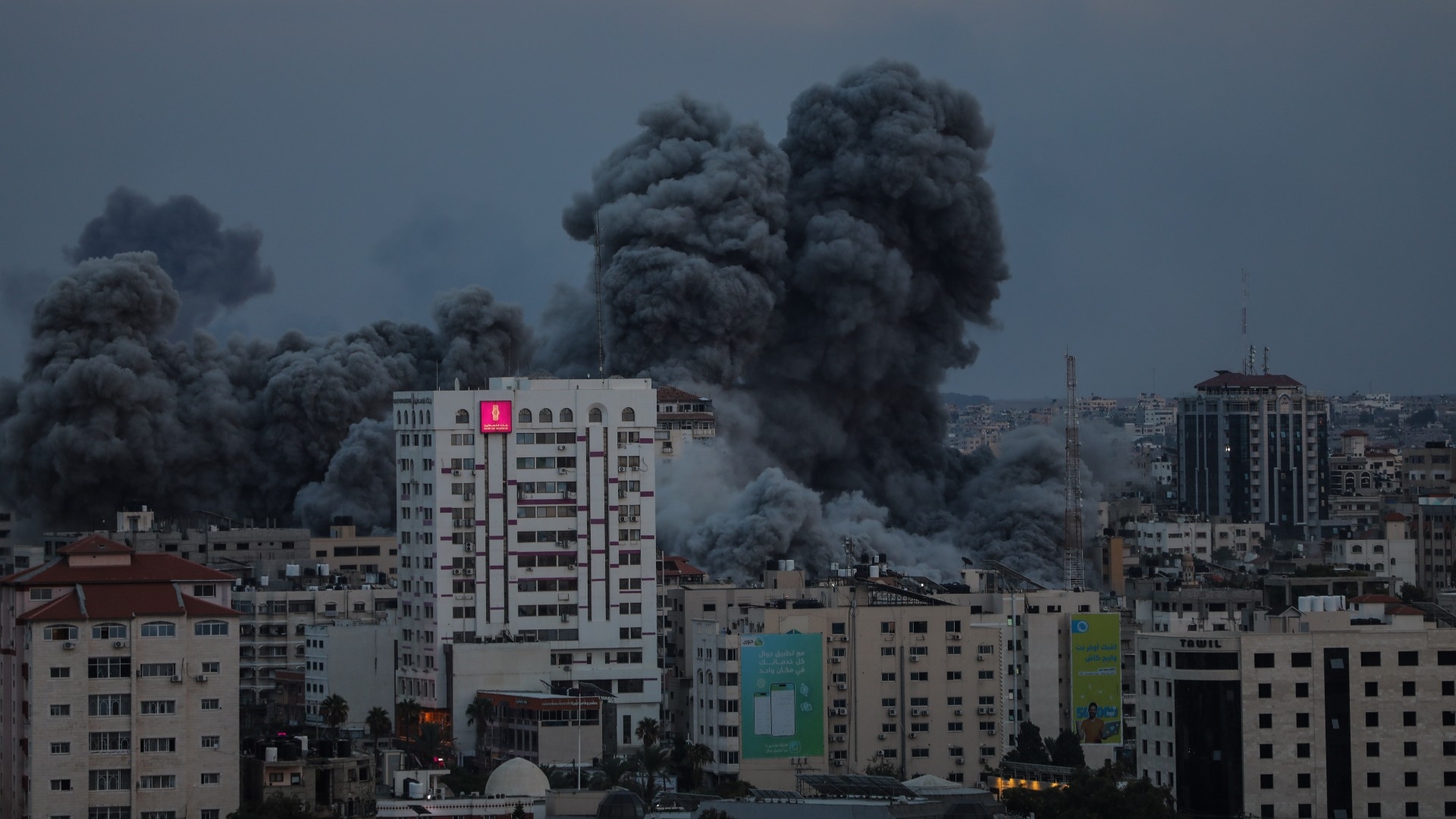 Israeli fighter jets can be seen bombing a high-rise residential building in Gaza City on 7 October, 2023 (MEE/Mohammed al-Hajjar)