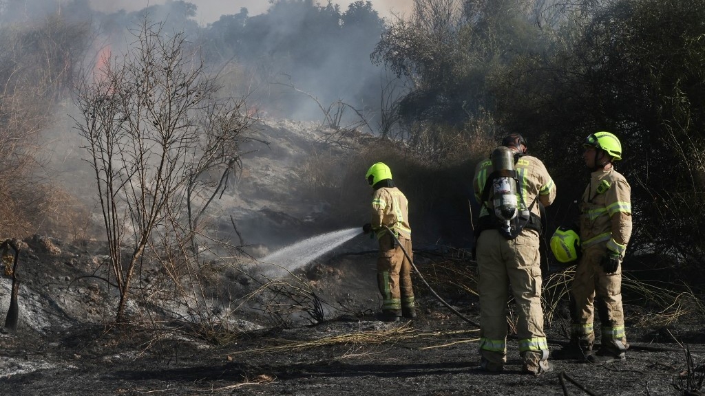 Responders put out a fire in the area of Lod, near Tel Aviv, in central Israel on 15 September 2024 after a missile fired from Yemen crossed into central Israel  and "fell in an open area", according to the Israeli army (AFP/Menahem Kahana)