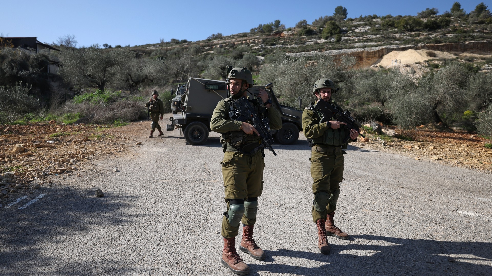 Members of Israeli security forces close-off the area where a Palestinian man was killed, northwest of Ramallah in the occupied West Bank, on 21 January 2023 (AFP)