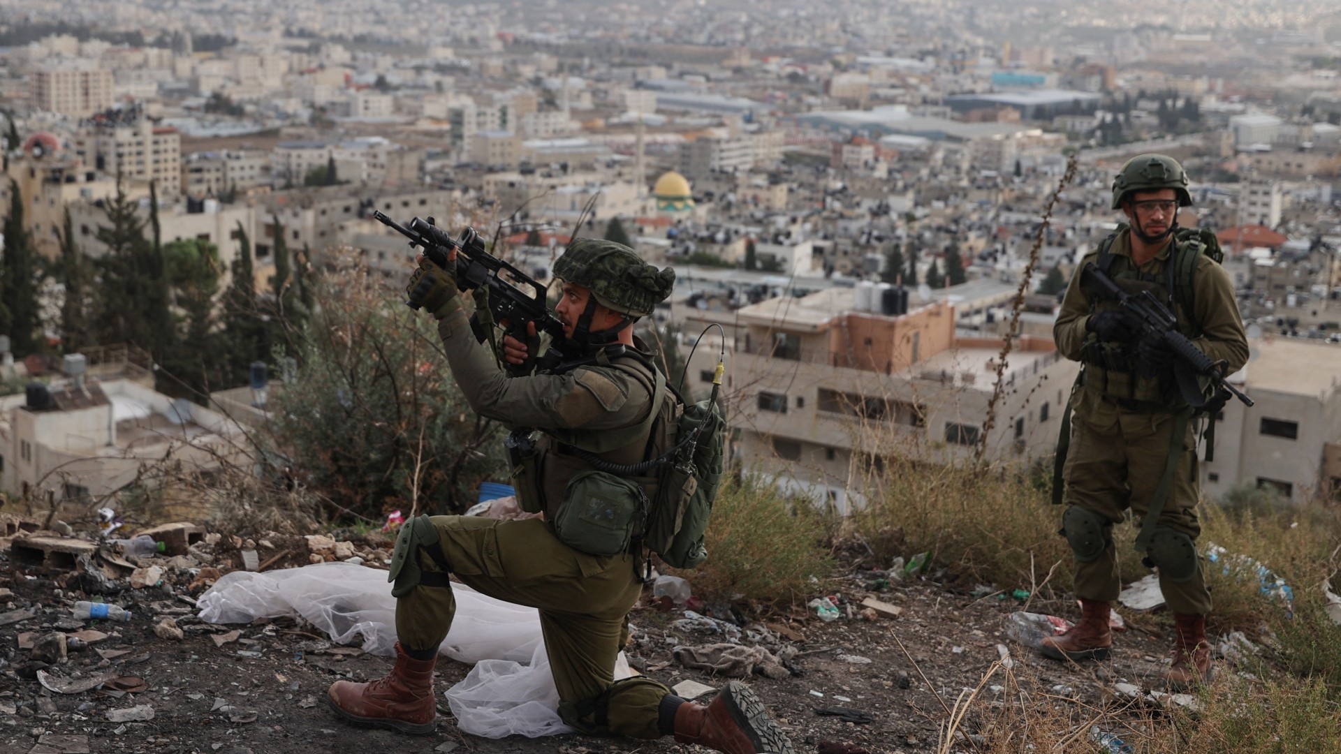 An Israeli soldier aims his rifle during a raid at the Balata refugee camp, east of Nablus in the occupied West Bank on 19 November 2023 (AFP)