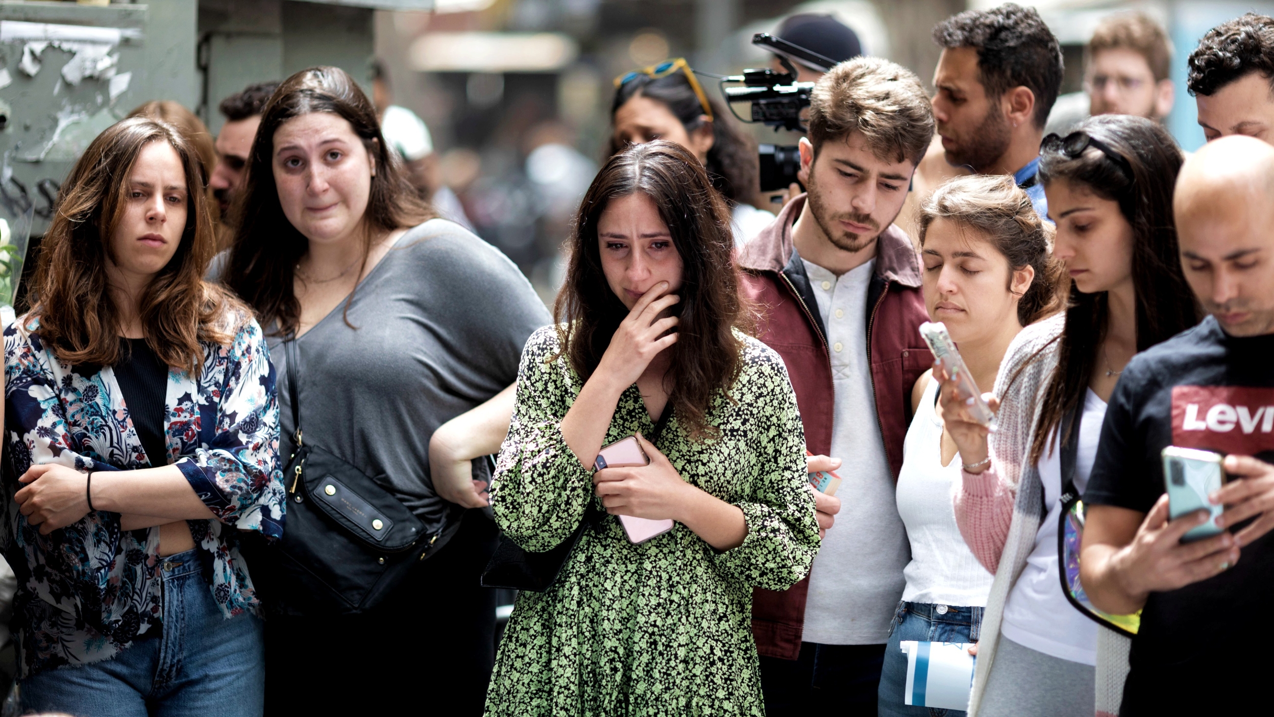 Israelis gather outside the site of the shooting in a bar in Dizengoff Street in central Tel Aviv. (MEE/Oren Ziv)