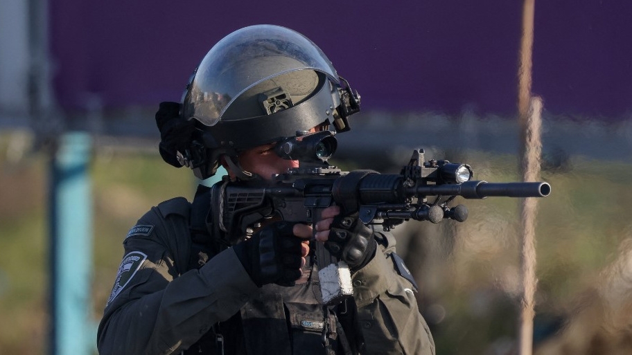Un soldat israélien pointe son fusil vers des manifestants palestiniens, le 26 janvier 2023 près de la colonie juive de Beit El, en Cisjordanie occupée (AFP)