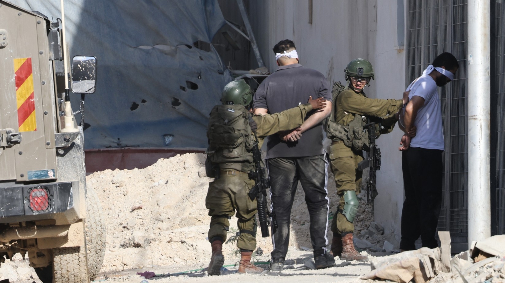 Israeli soldiers arrest two Palestinian men during a raid in the Nur Shams camp near the city of Tulkarm in the Israeli-occupied West Bank on 28 August 2024 (Jaafar Ashtiyeh/AFP)