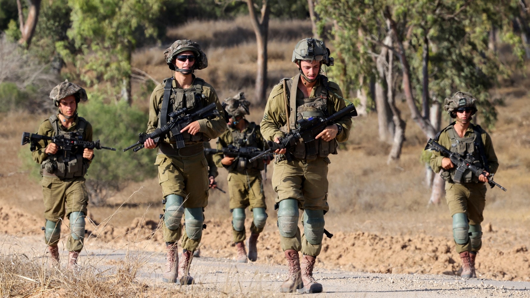 Israeli army soldiers patrol around a position along Israel's southern border with the Gaza Strip on 13 June 2024 (Jack Guez/AFP)