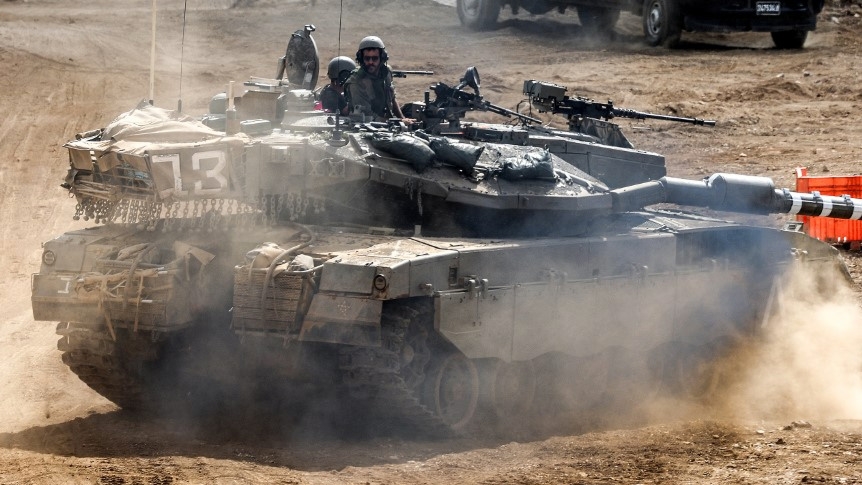 An Israeli tank moves along the border with Lebanon on 1 October 2024 (Ahmad Gharabli/AFP)