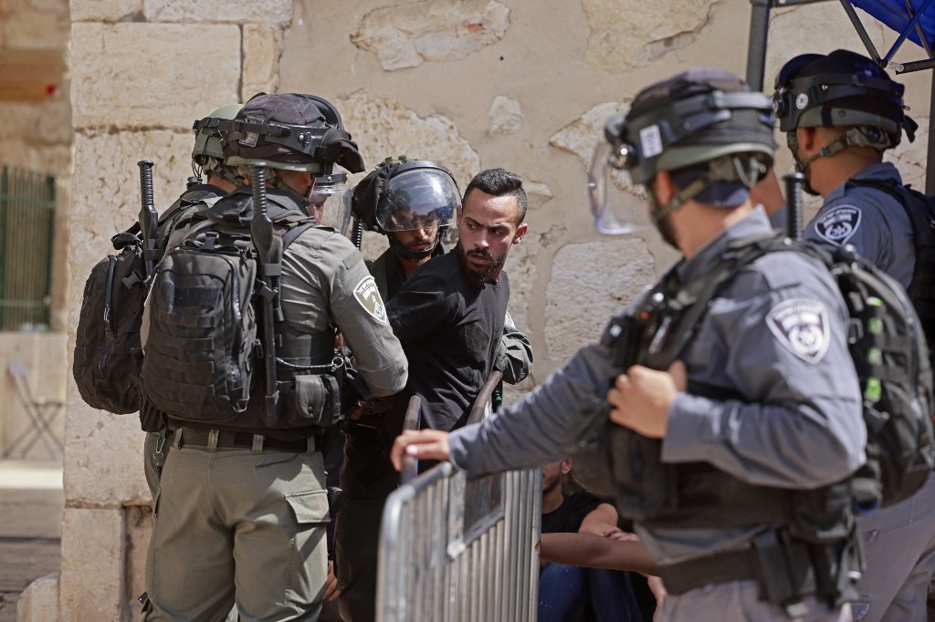Israeli security forces detain a man at the entrance of Jerusalem's al-Aqsa mosque on 21 May 2021
