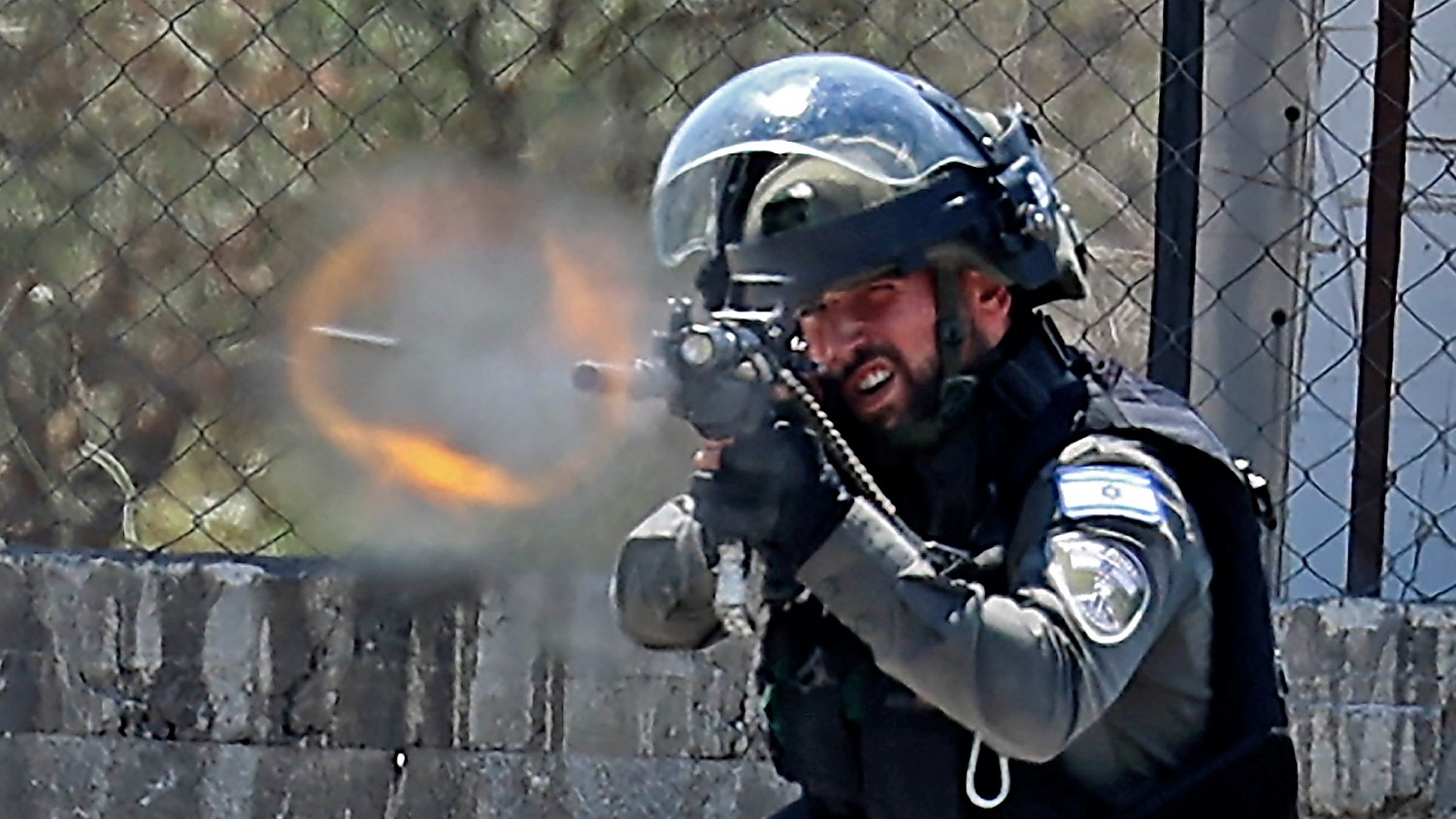 A member of the Israeli border police fires rubber bullets toward Palestinian demonstrators, during clashes with them in the West Bank town of Beita south of Nablus, on 3 June 2022.