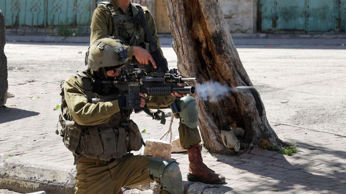 Israeli soldiers fire rubber bullets towards Palestinian protesters following the death announcement of a Palestinian hunger striker who was in Israeli detention, on 2 May 2023, in Hebron, in the occupied West Bank.