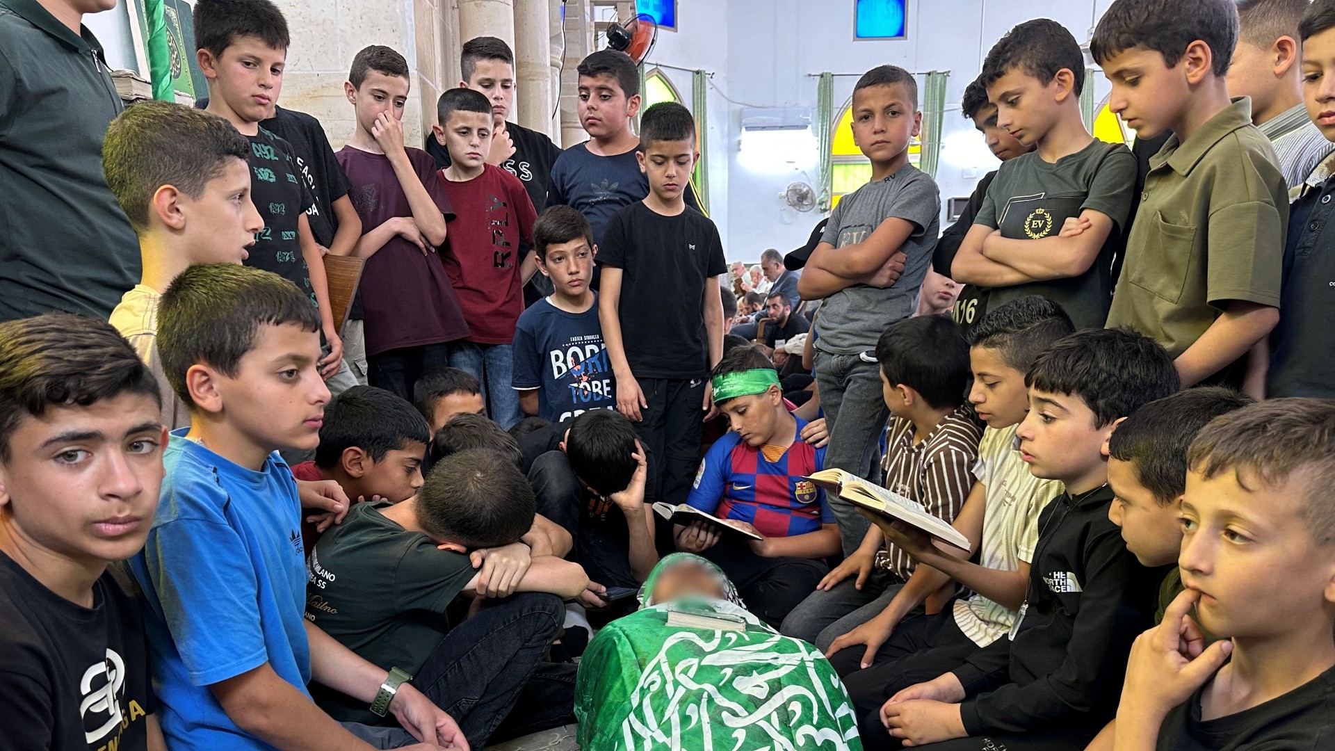 Students gather around the body of their school teacher, Allam Jaradat, who was killed by Israeli forces in Jenin in the occupied West Bank 21 May 2024 (Reuters/Ali Sawafta)