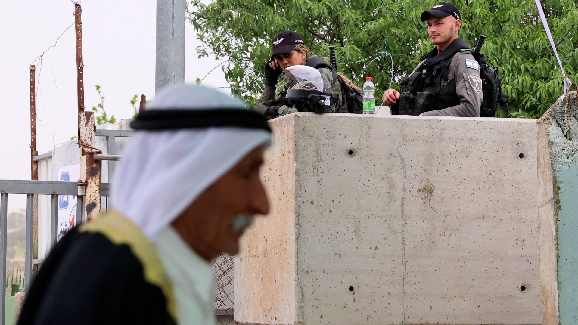 Israeli forces keep watch as Palestinians wait to have their IDs checked at a checkpoint in Bethlehem in the occupied West Bank on 8 April 2022.