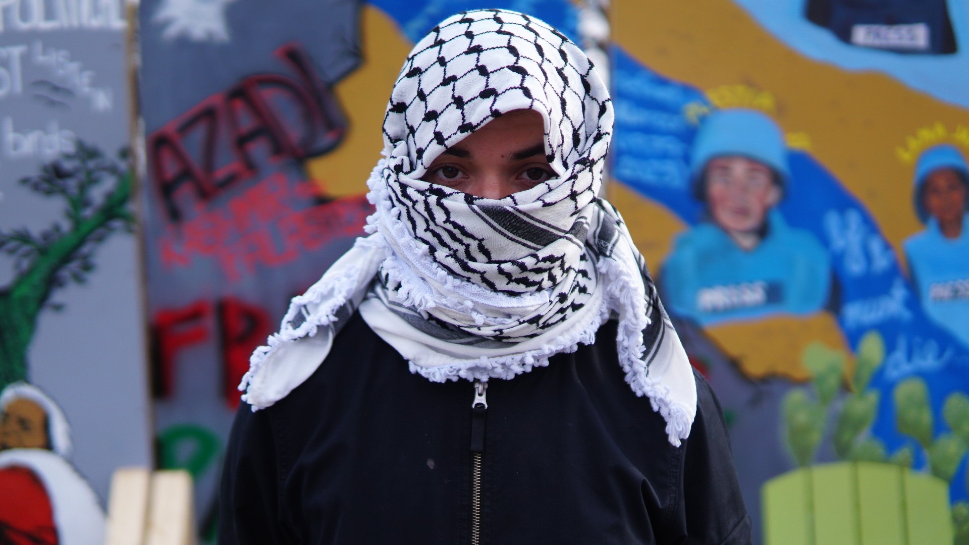 A Jewish student wears a keffiyeh to shield their identity at a Gaza solidarity encampment at Tufts University on 3 May, 2024 (Azad Essa/MEE)
