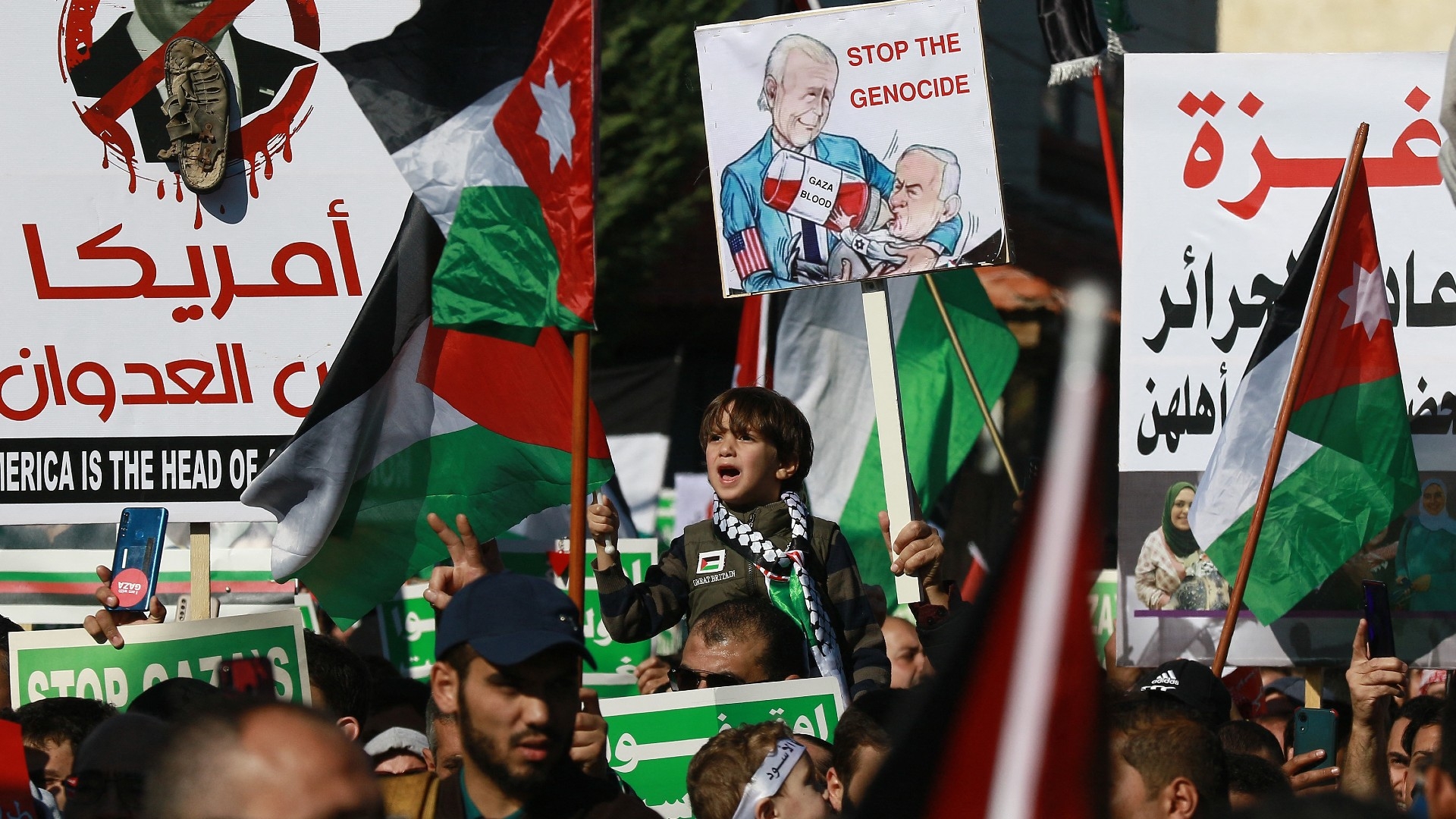 People chant slogans and wave Palestinian and Jordanian flags during a demonstration near the US embassy in the capital Amman on 15 December, 2023 (Khalil Mazraawi/AFP)