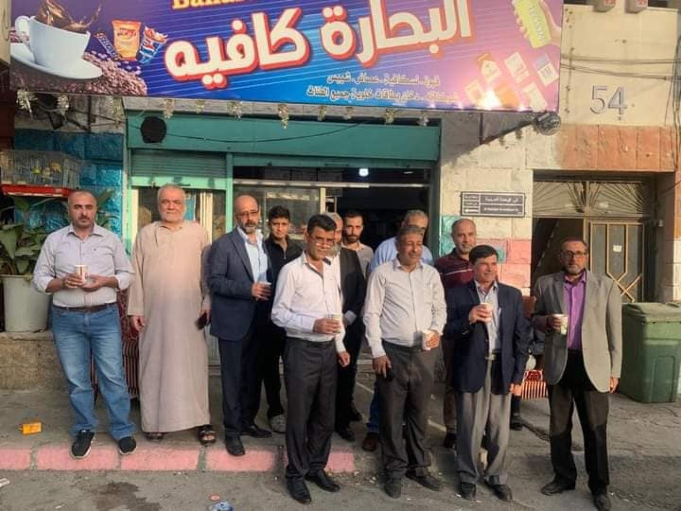 Des activistes politiques devant le café de Kameel al-Zoubi dans le quartier de Ramtha, réunis pour acheter des boissons en signe de soutien au propriétaire emprisonné (MEE/Jahid Abu Baidar)