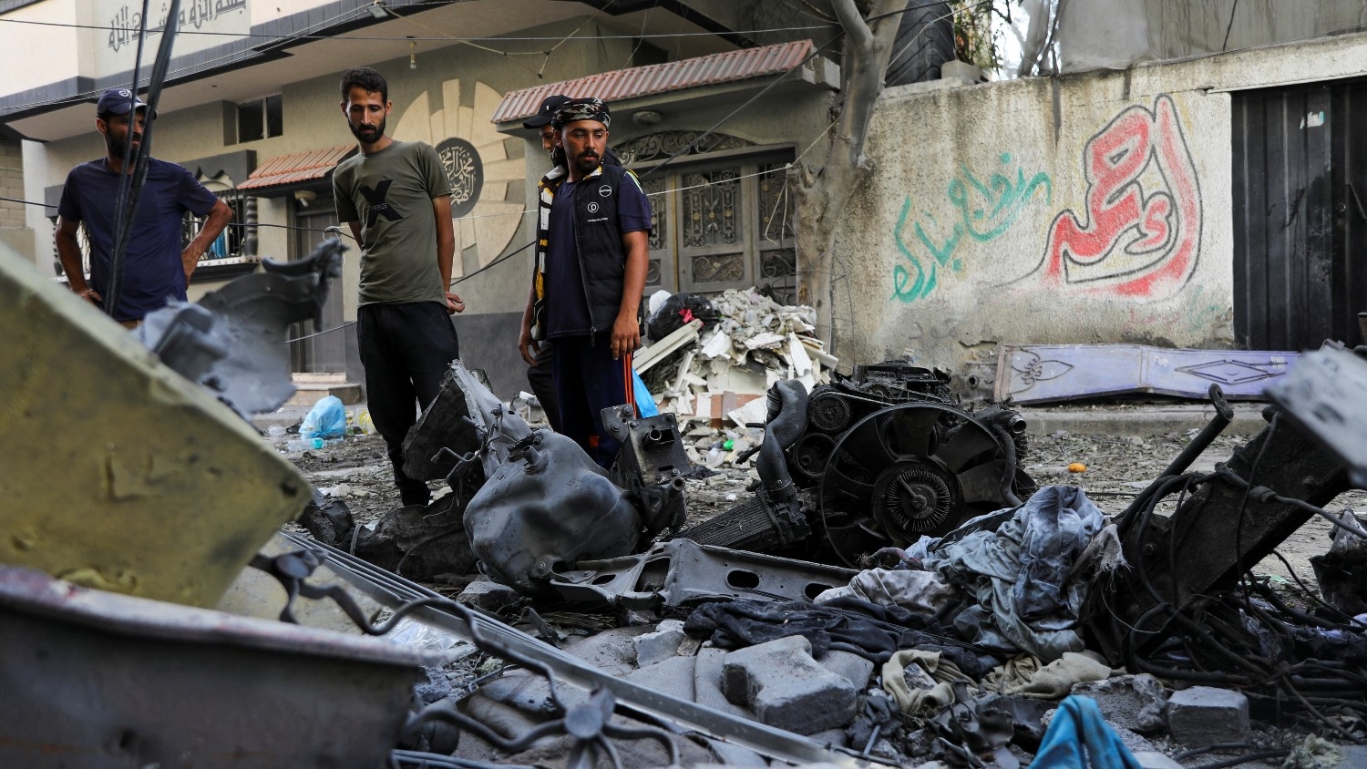 Men stand among debris of an Israel operation that killed more than 200 Palestinians in order to rescue four hostages in Nuseirat refugee camp central Gaza on 9 June 2024.